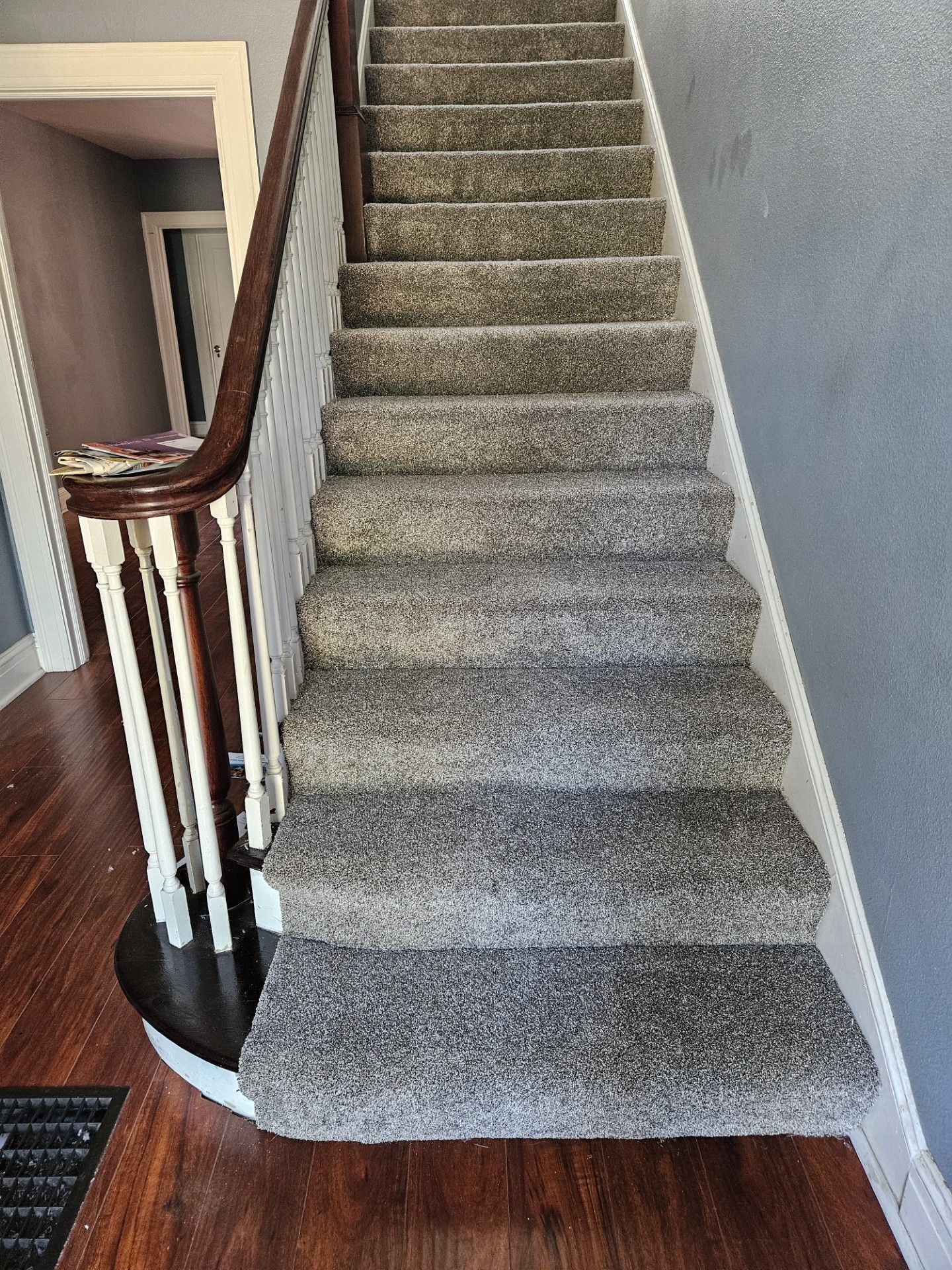 A staircase with carpeted steps and a wooden railing in a house.