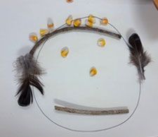 A black and white drawing of a face with feathers as ears from a child