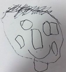 A drawing of a face with big circle eyes and a rectangle nose made by a child