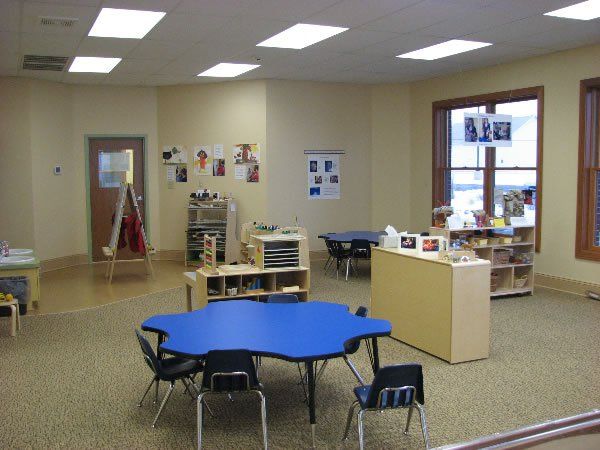 A classroom with a blue table and chairs