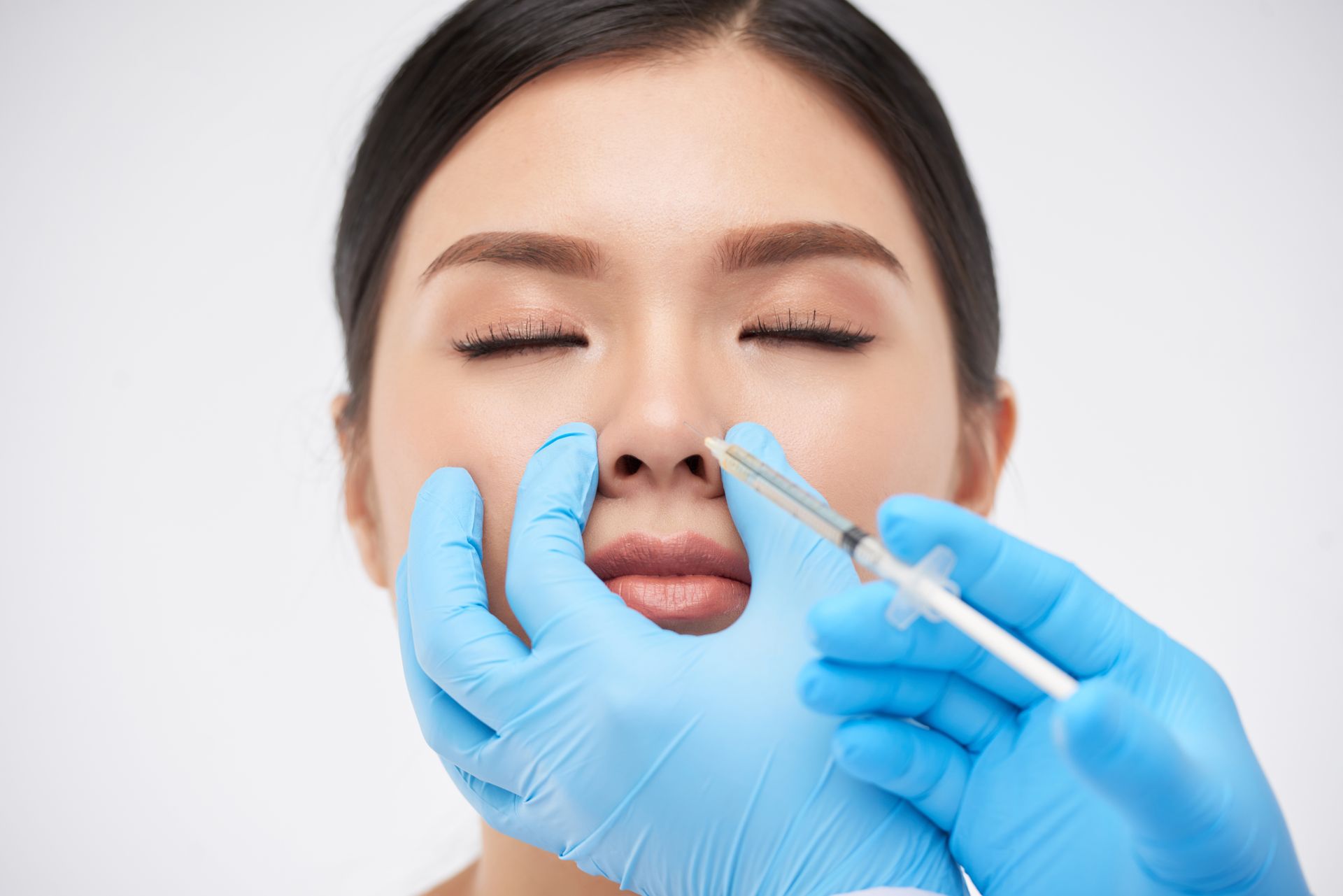 A woman is getting an injection in her nose.