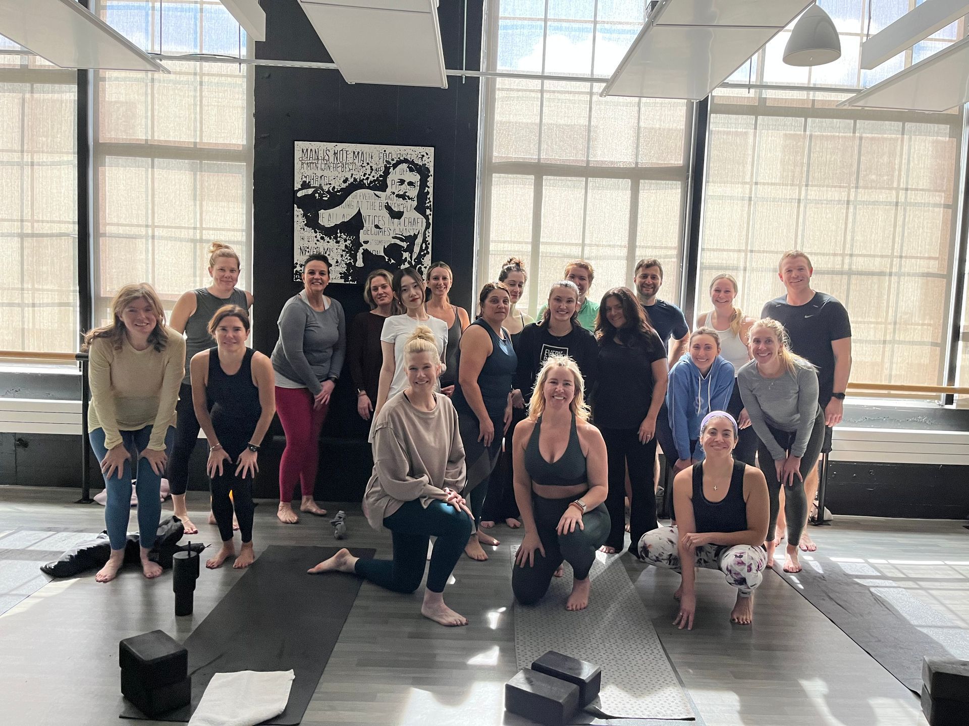 A group of people are posing for a picture in a yoga studio for fundraiser.