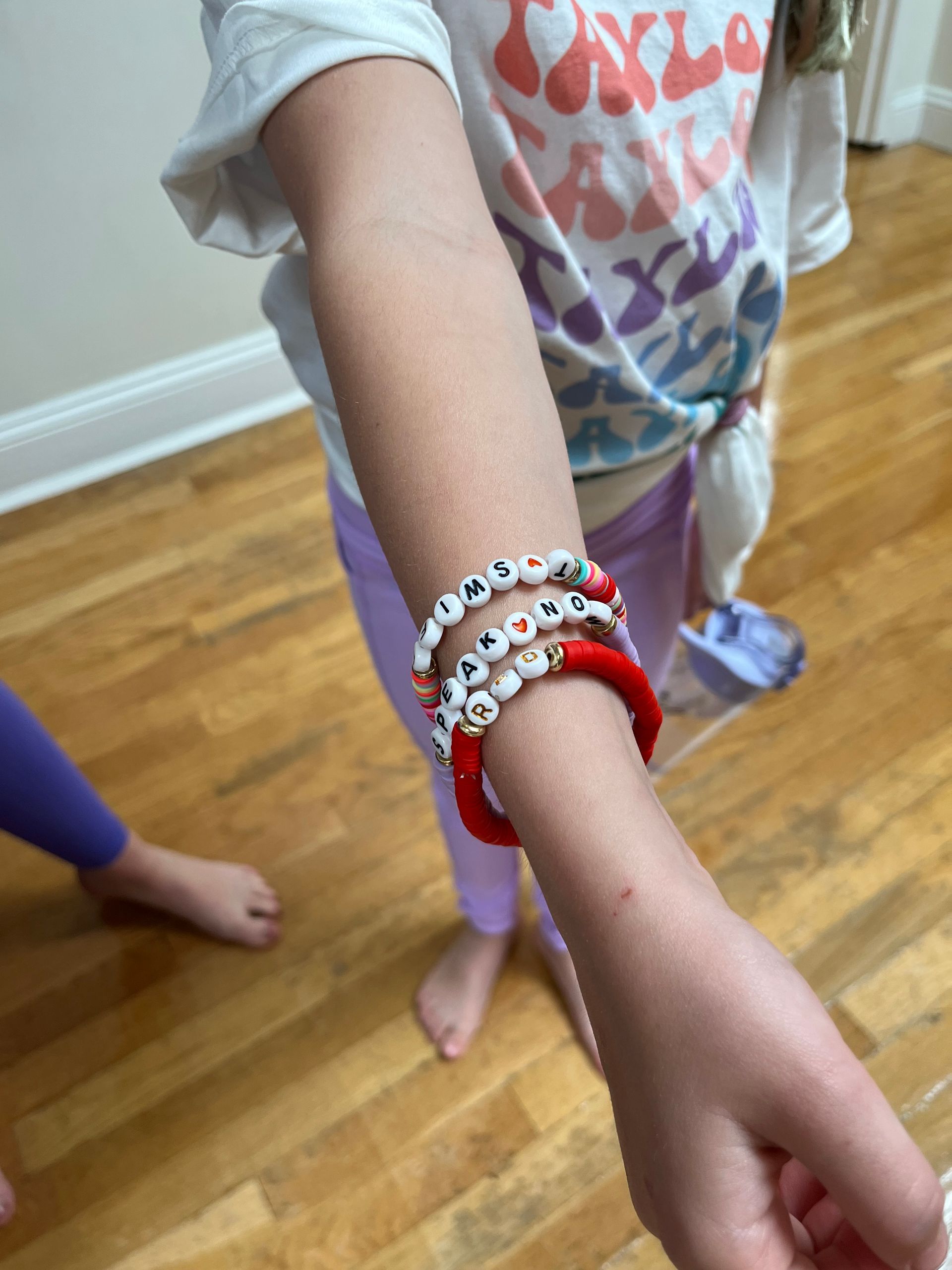 A little girl wearing a stack of bracelets on her wrist for inspiration