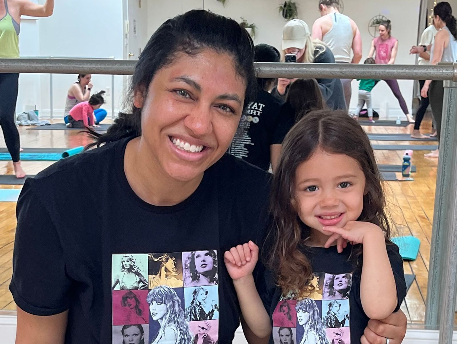 A woman and a little girl are posing for a picture in a gym.