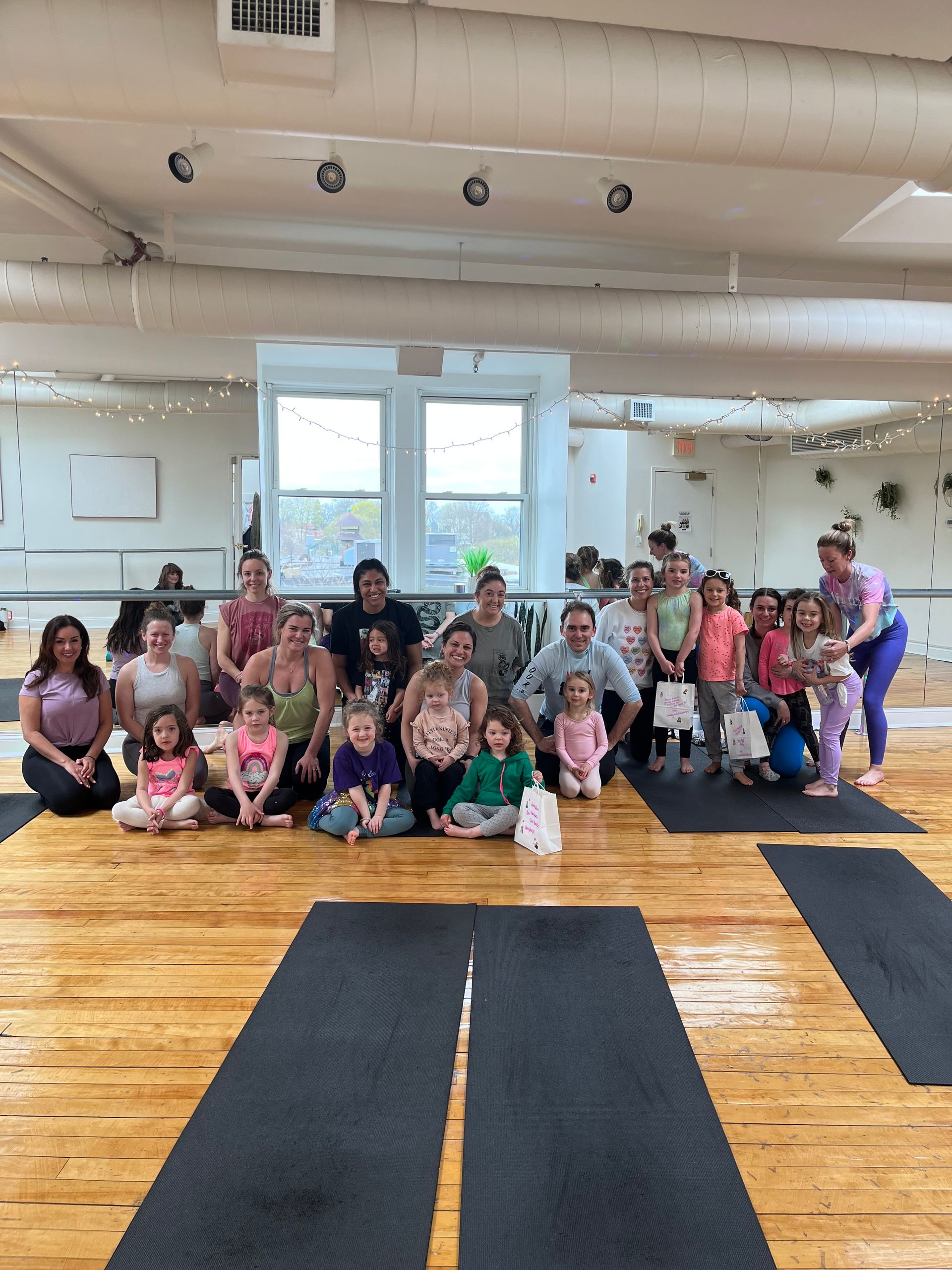A group of people are posing for a picture in a dance studio.