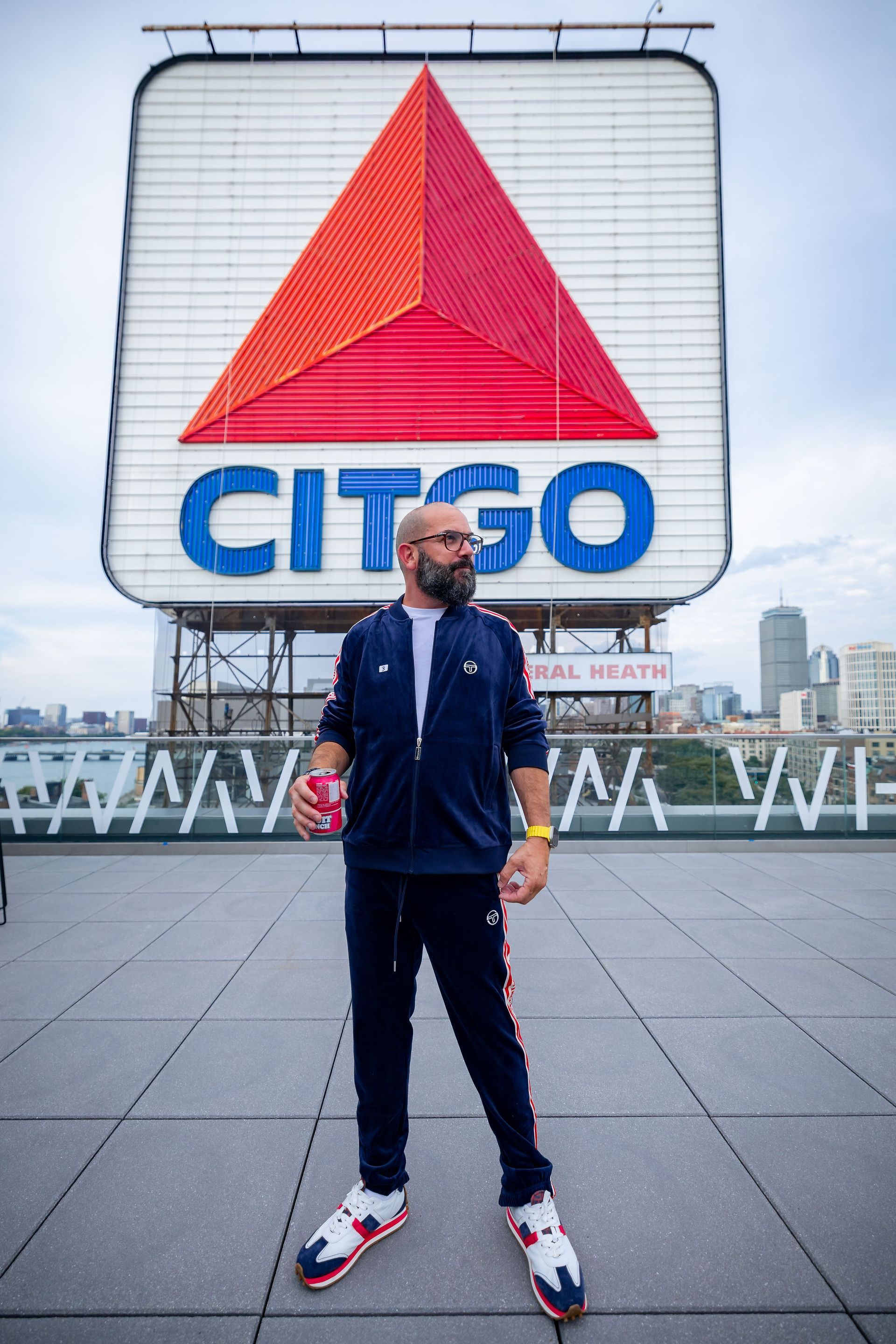 A man is standing in front of a citgo sign for fundraiser for rare diseases.