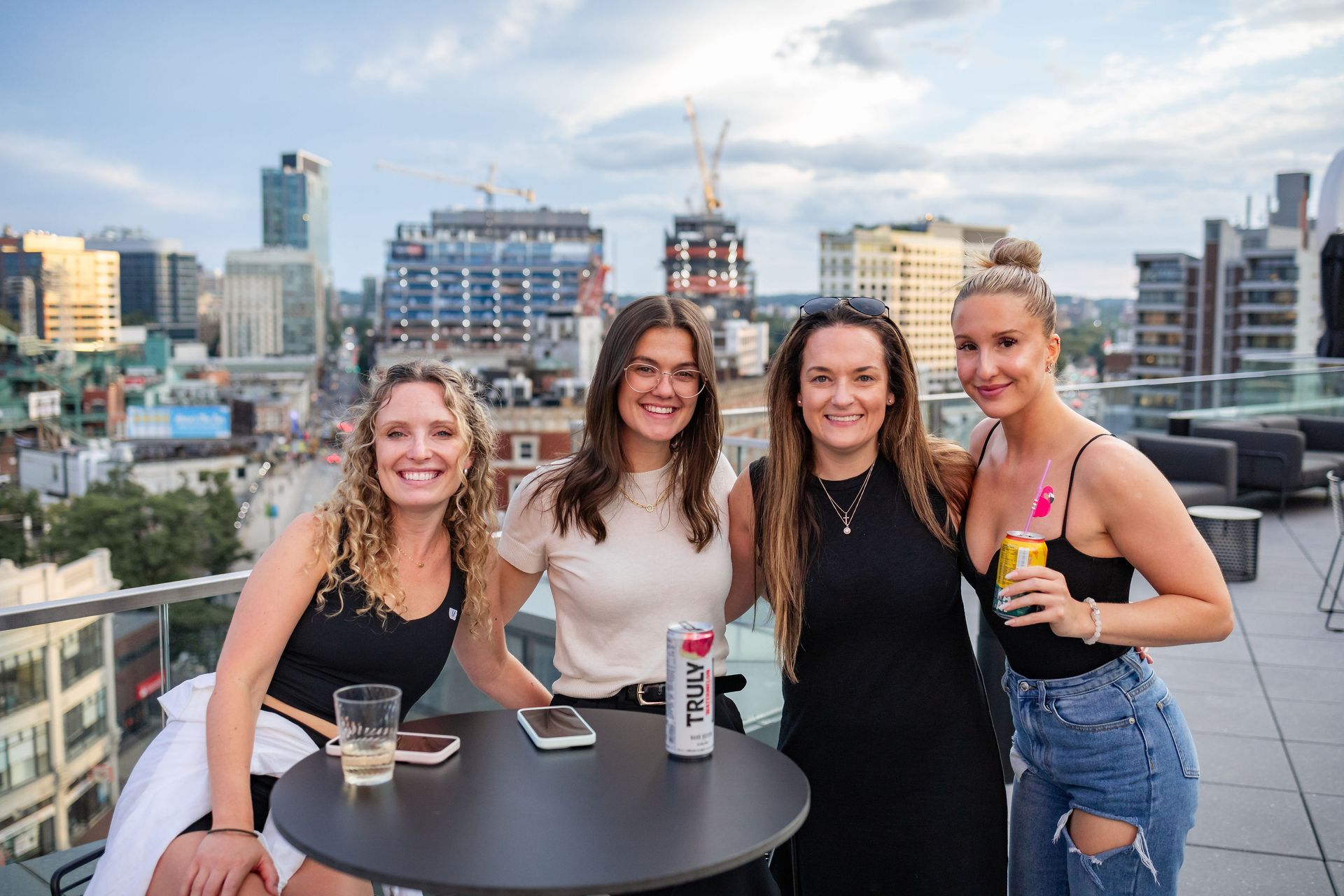 A group of women are posing for a picture while sitting around a table.