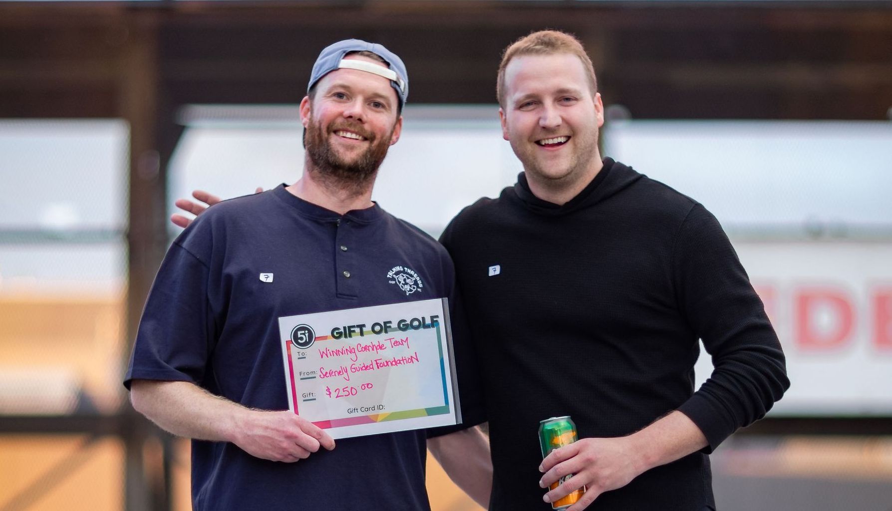 Two men are standing next to each other and one of them is holding a sign.