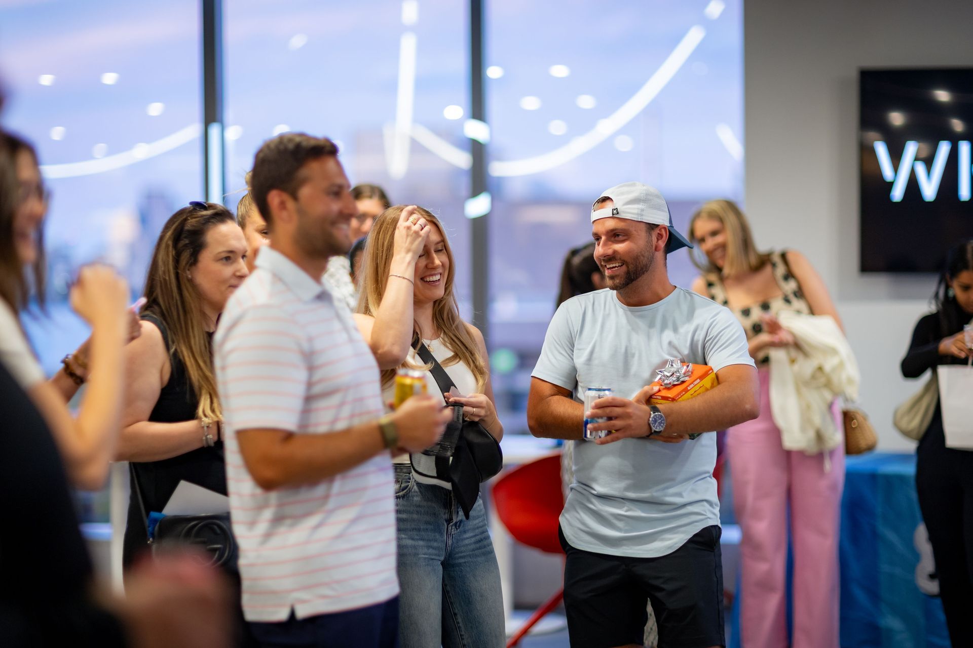 A group of people are standing in a room talking to each other.