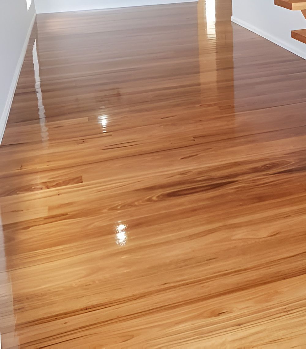 A Close Up Of A Wooden Floor In A Room With Stairs — Kyall Chalker Floor Sanding & Polishing In Port Macquarie, NSW