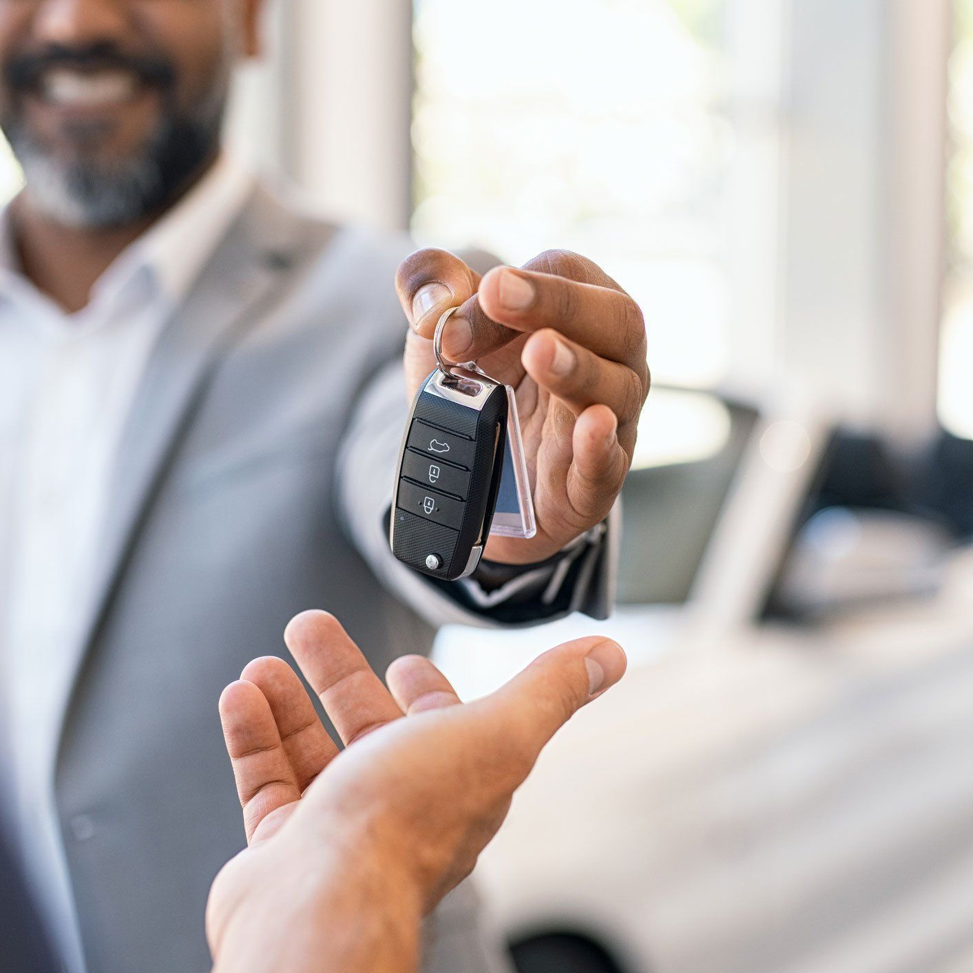 Man giving a car key to the owner
