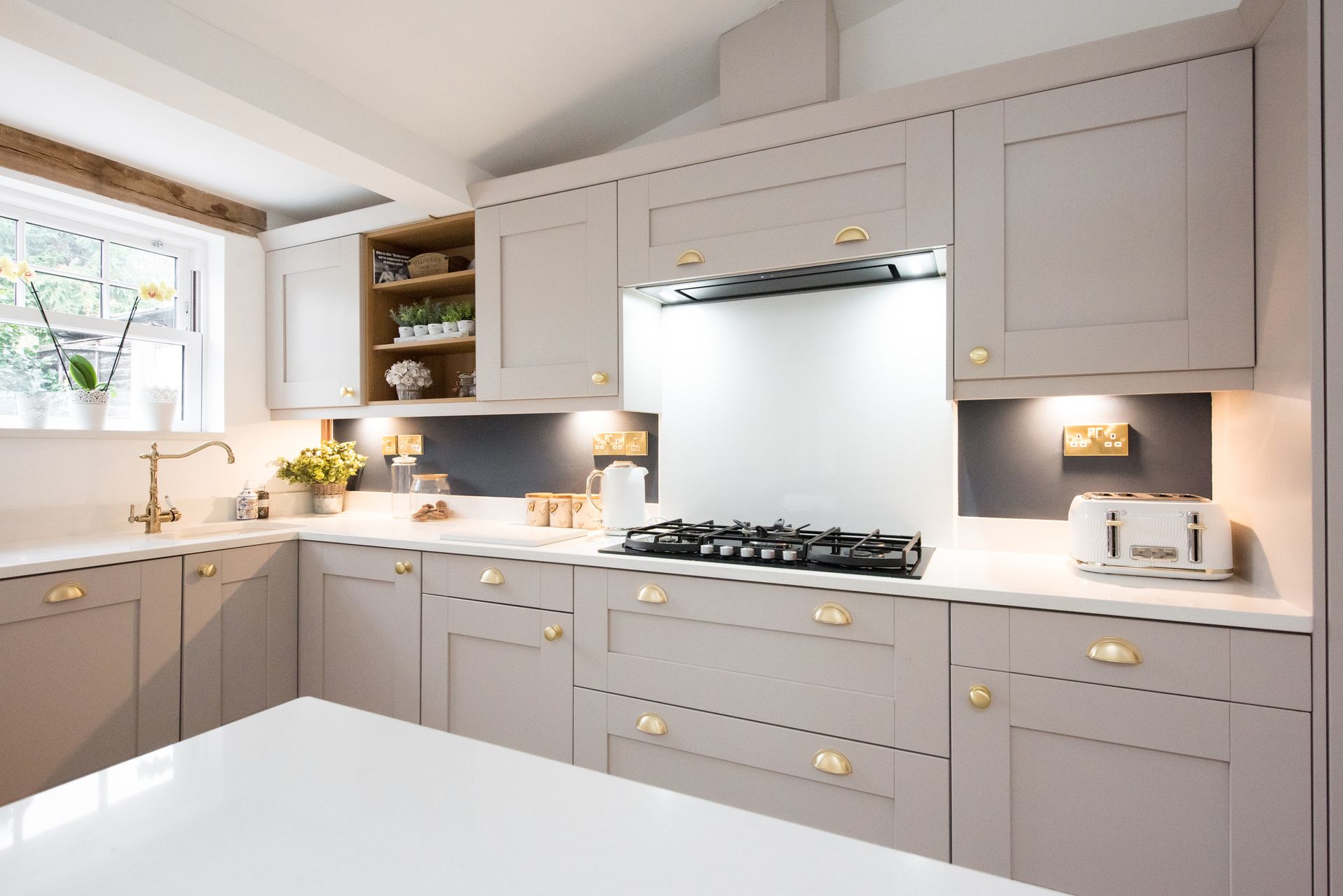 A kitchen with gray cabinets and white counter tops