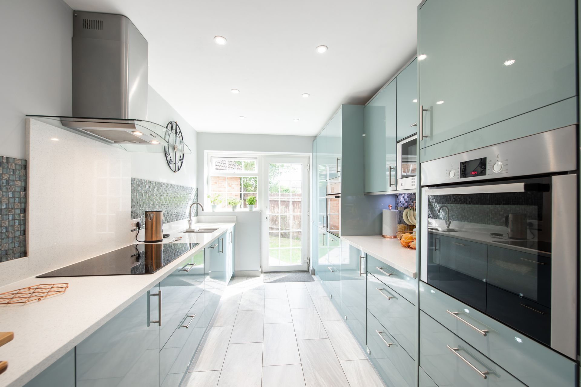 A kitchen with blue cabinets and stainless steel appliances.