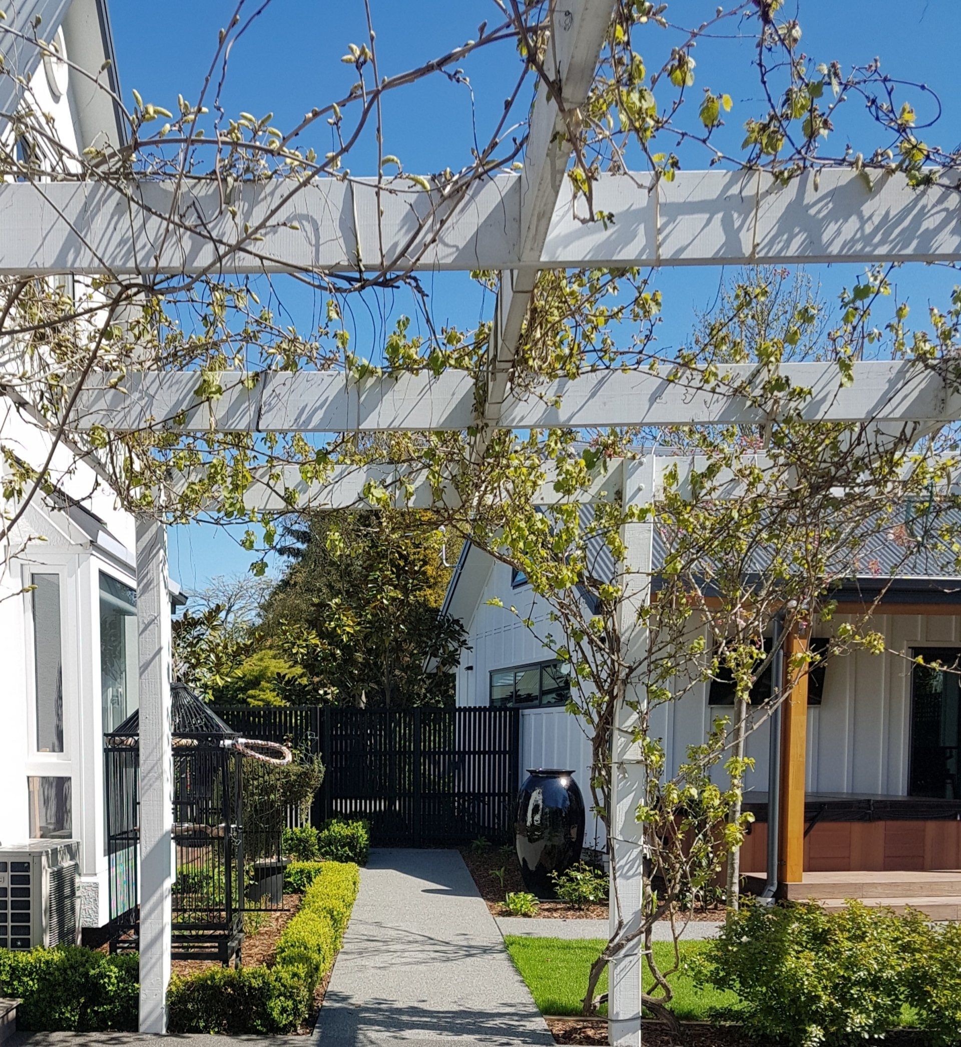 A white house with a pergola in front of it