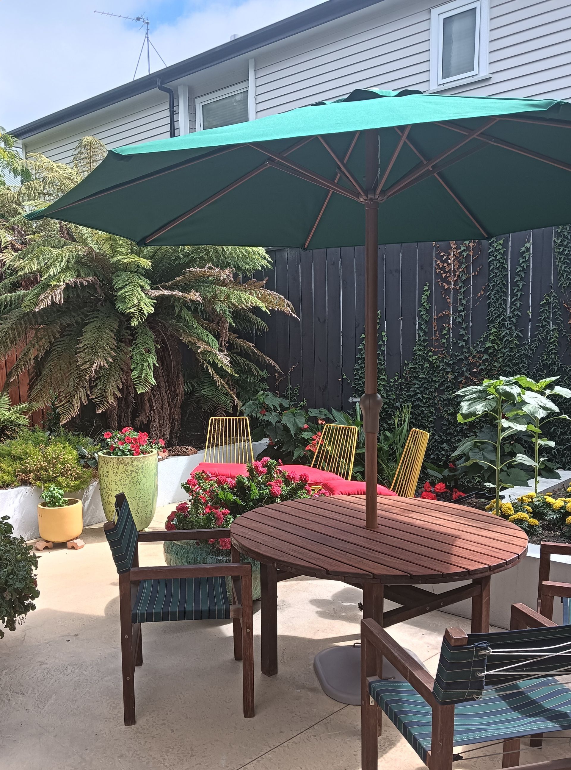 A patio with a table and chairs under an umbrella