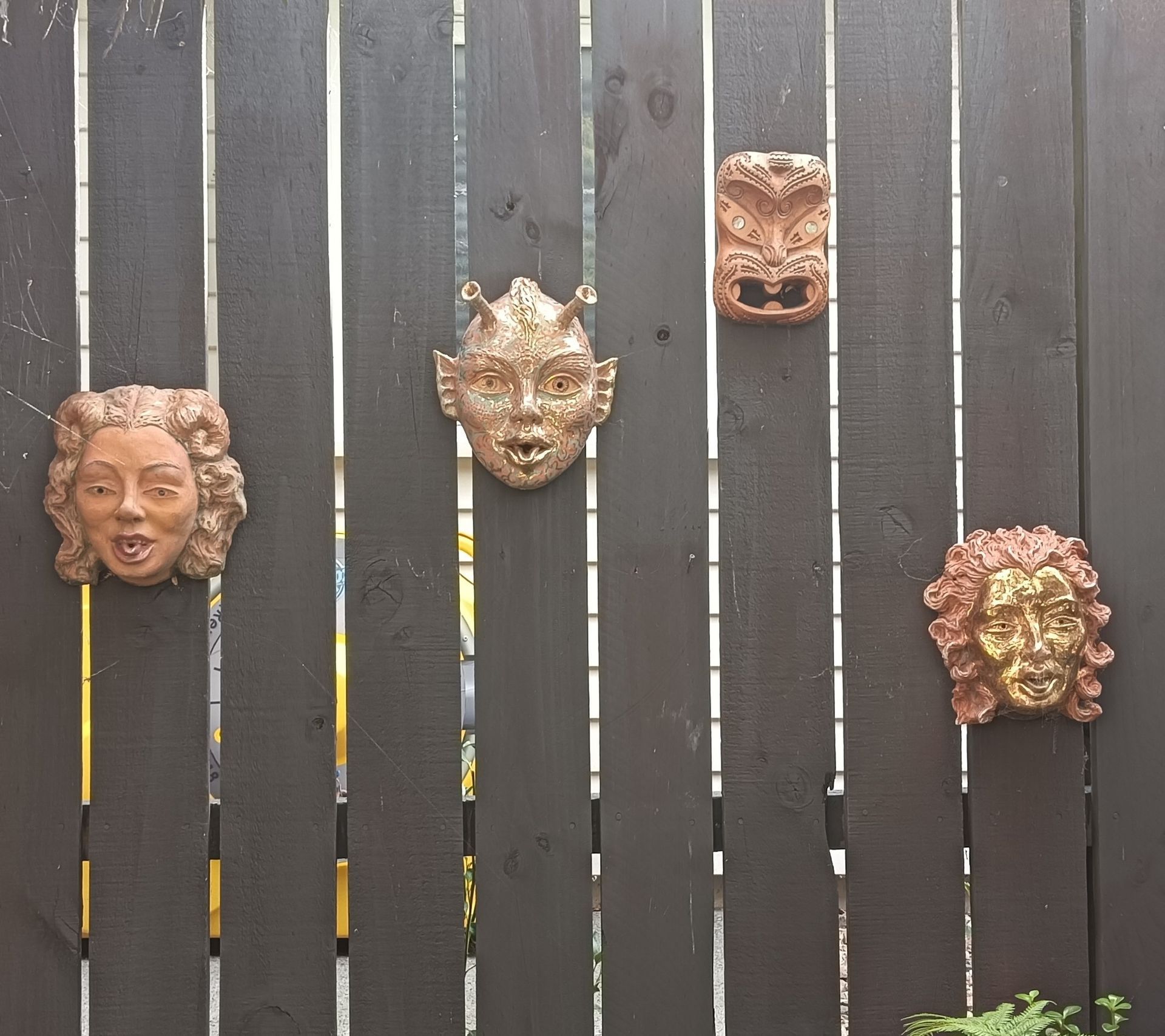 A wooden fence with three faces on it