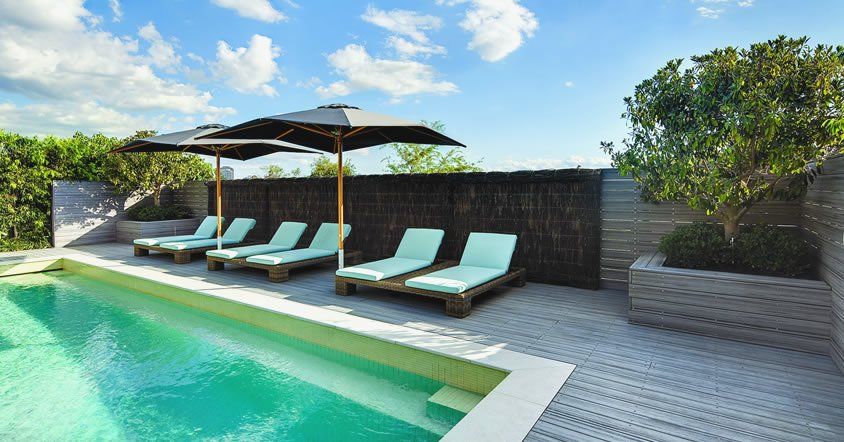 A swimming pool with chairs and umbrellas around it