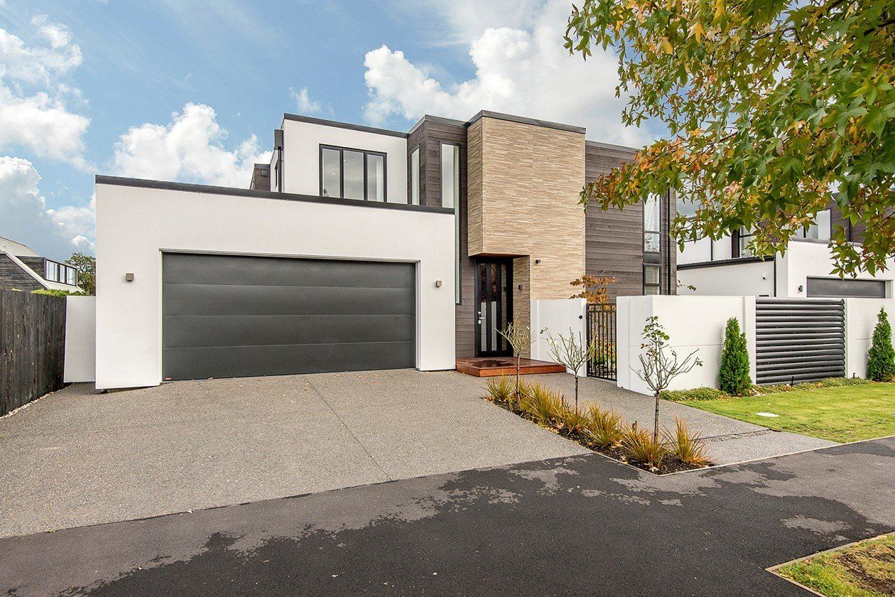 A large white house with a black garage door