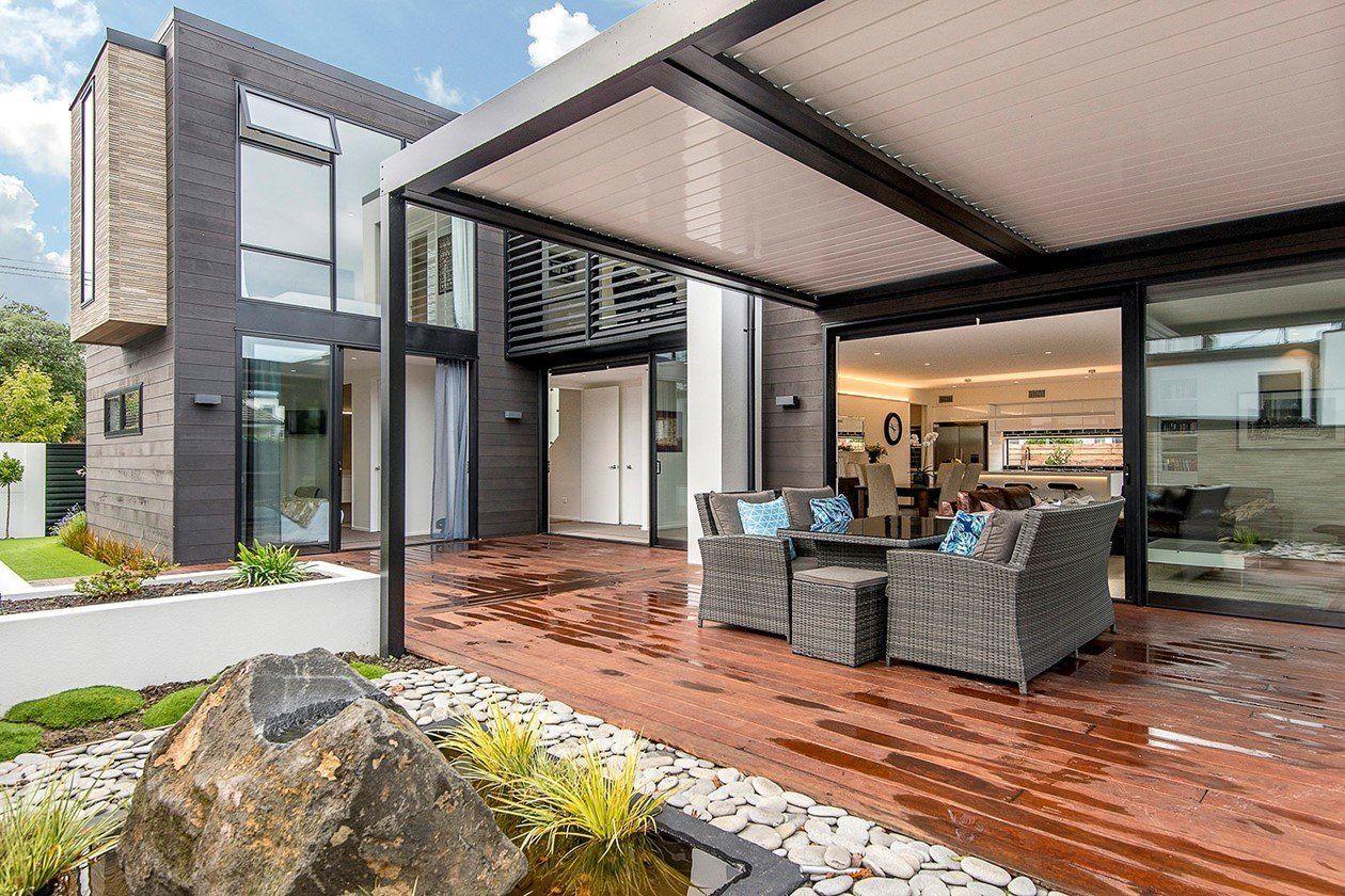 A large house with a pergola and patio furniture