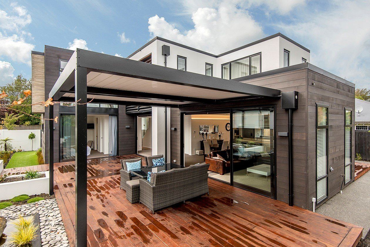 A large house with a large deck and a pergola