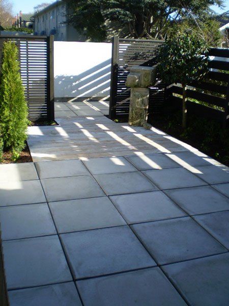 A patio with a fence and a statue in the background