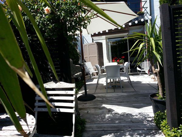 A patio with a table and chairs under an umbrella