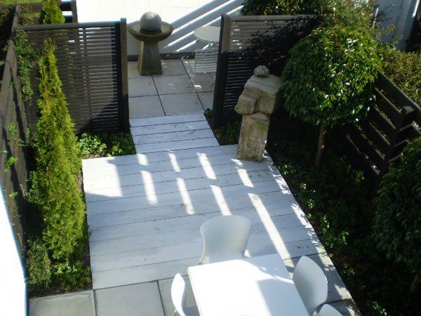A patio with a table and chairs and a fence