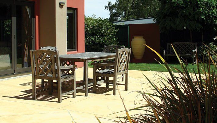A table and chairs on a patio in front of a house