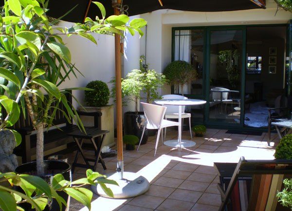 A patio with a table and chairs under an umbrella