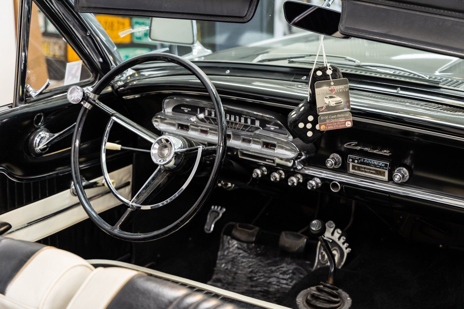 The interior of an old car with a steering wheel and dashboard.