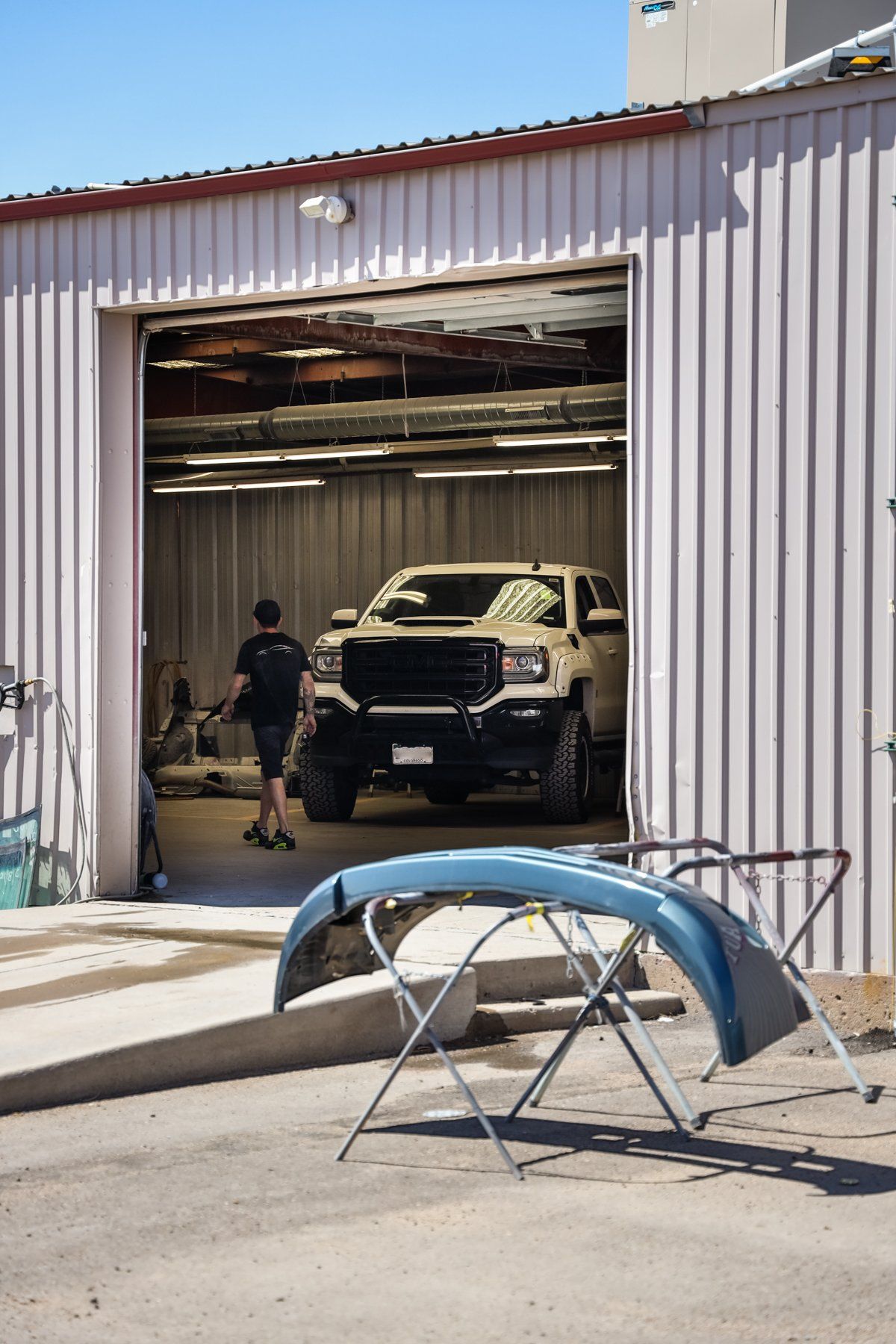 A truck is parked in a garage with the door open.