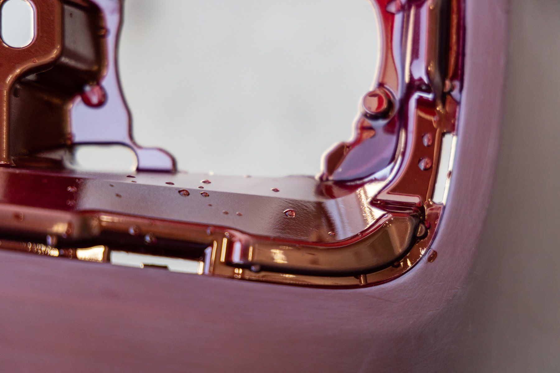 A close up of a pink and gold object on a white surface.