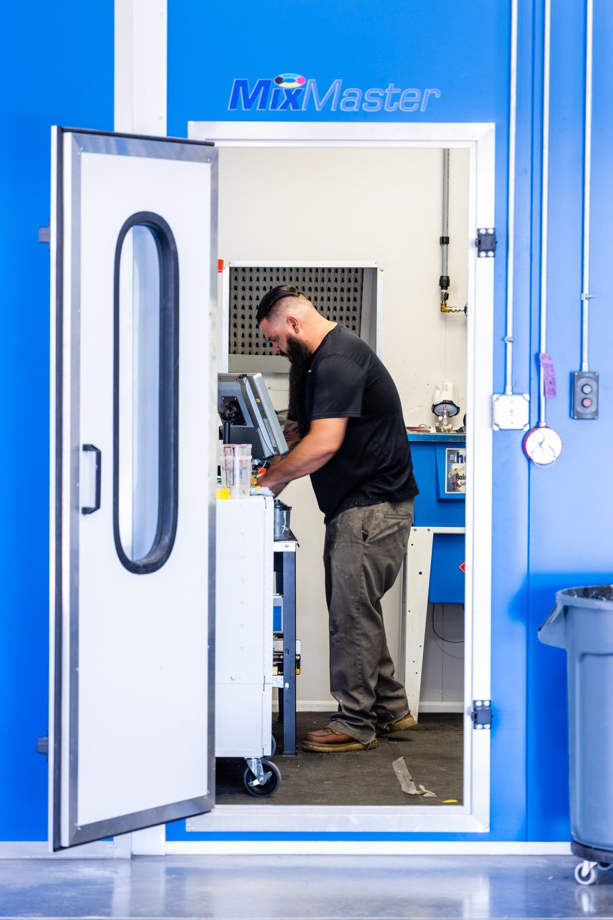 A man is working in a room with a door open.