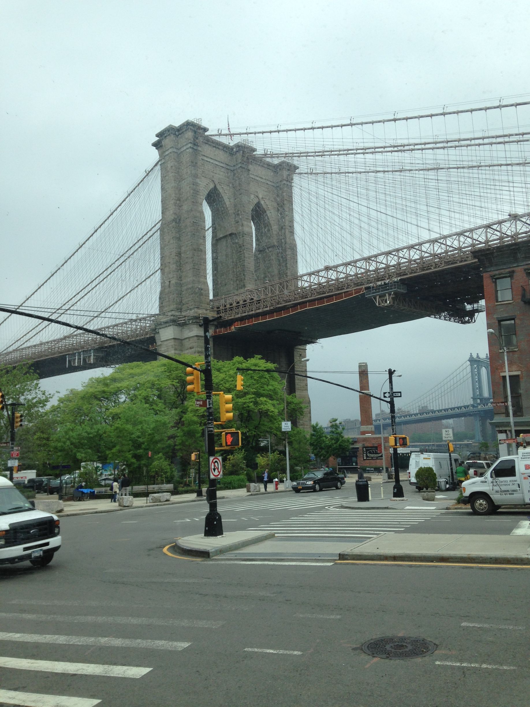A bridge over a city street with cars driving underneath it
