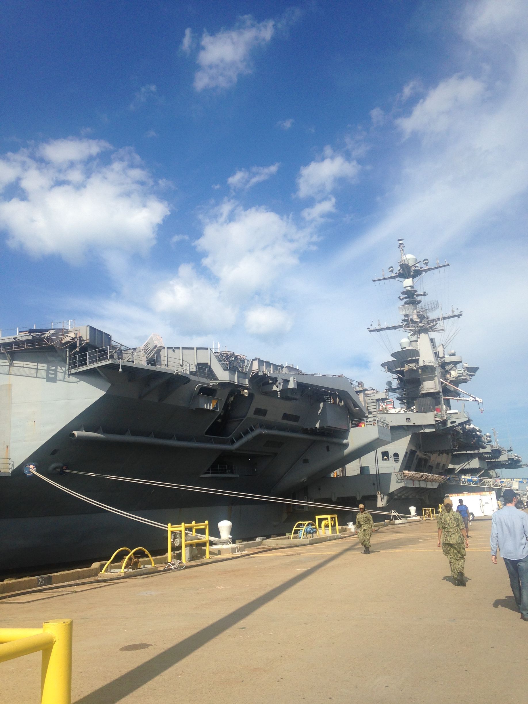 A large military ship is docked at a dock