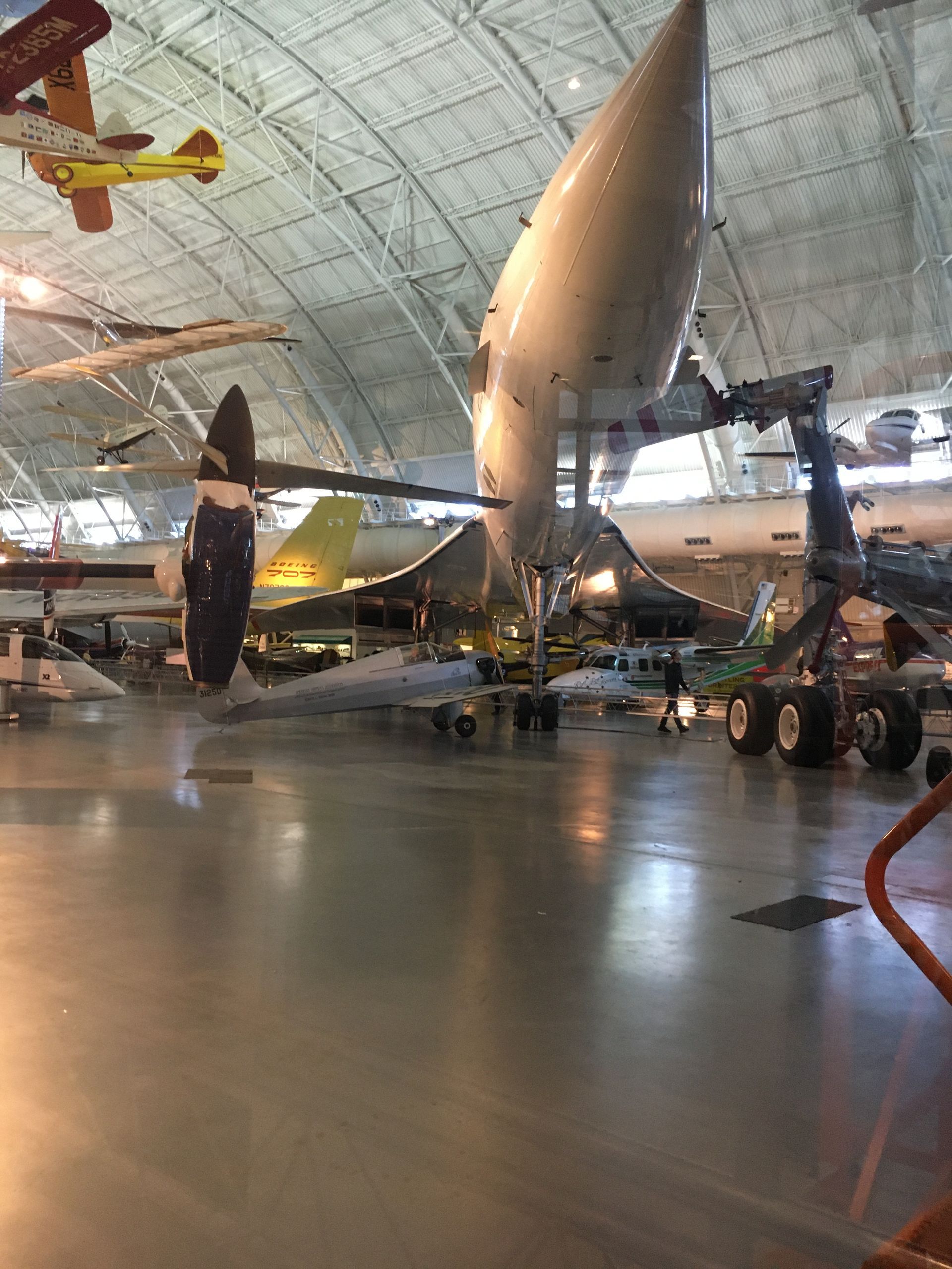A large hangar filled with lots of planes hanging from the ceiling.