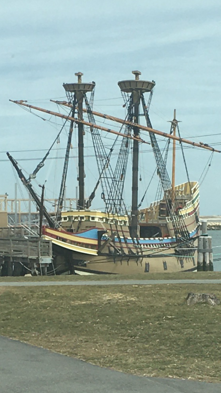 A large pirate ship is sitting on top of a grassy field.