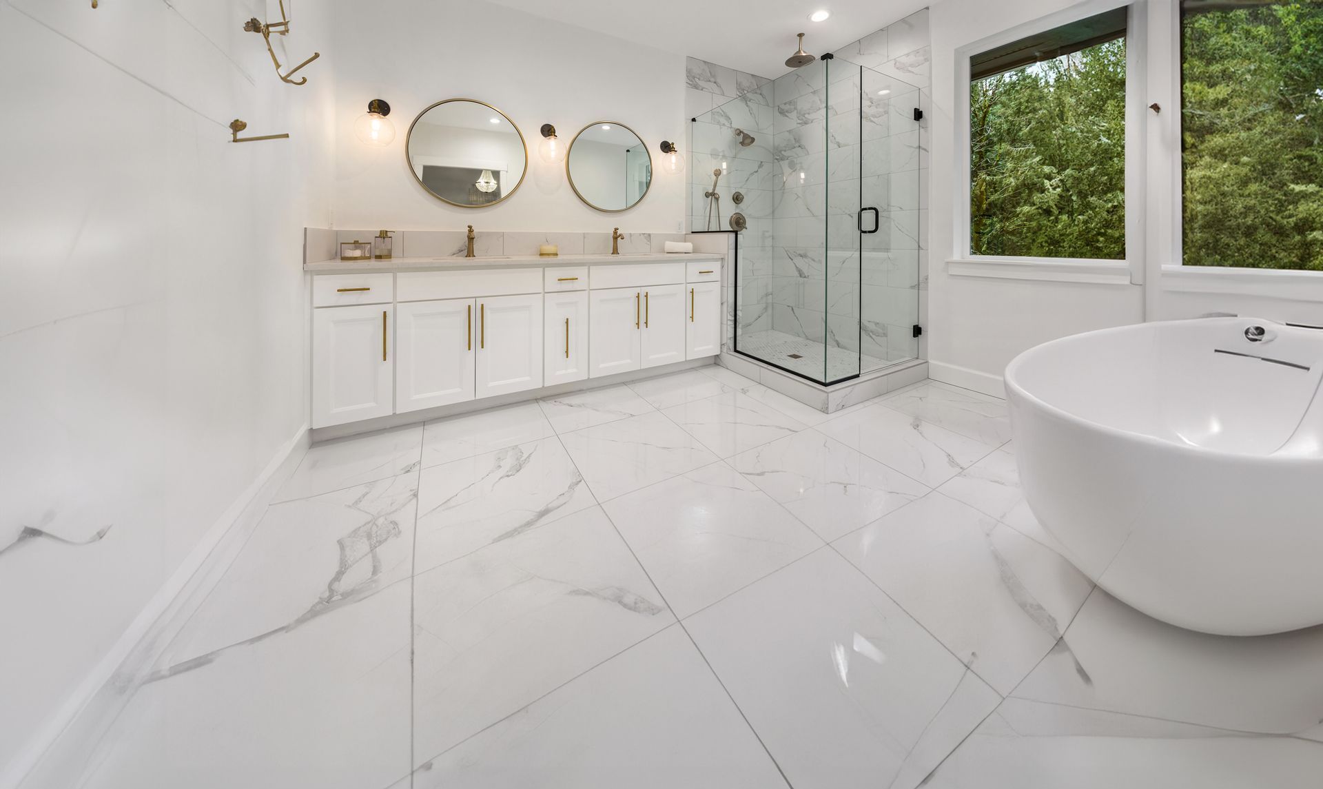 White marble bathroom with double vanity, shower, and freestanding tub.