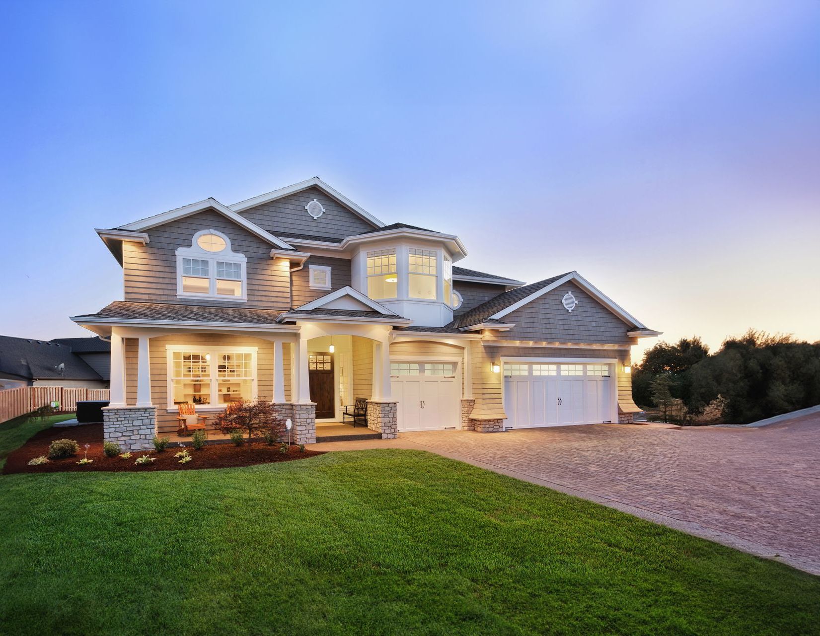 A large house with a lot of windows and a driveway.