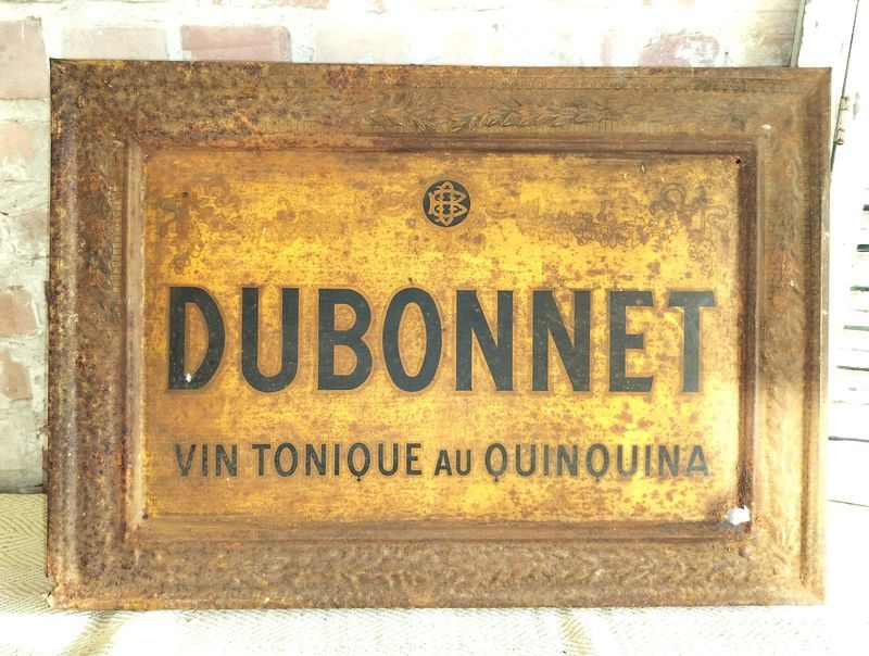 A rusty sign that says dubonnet vin tonique au quinquina