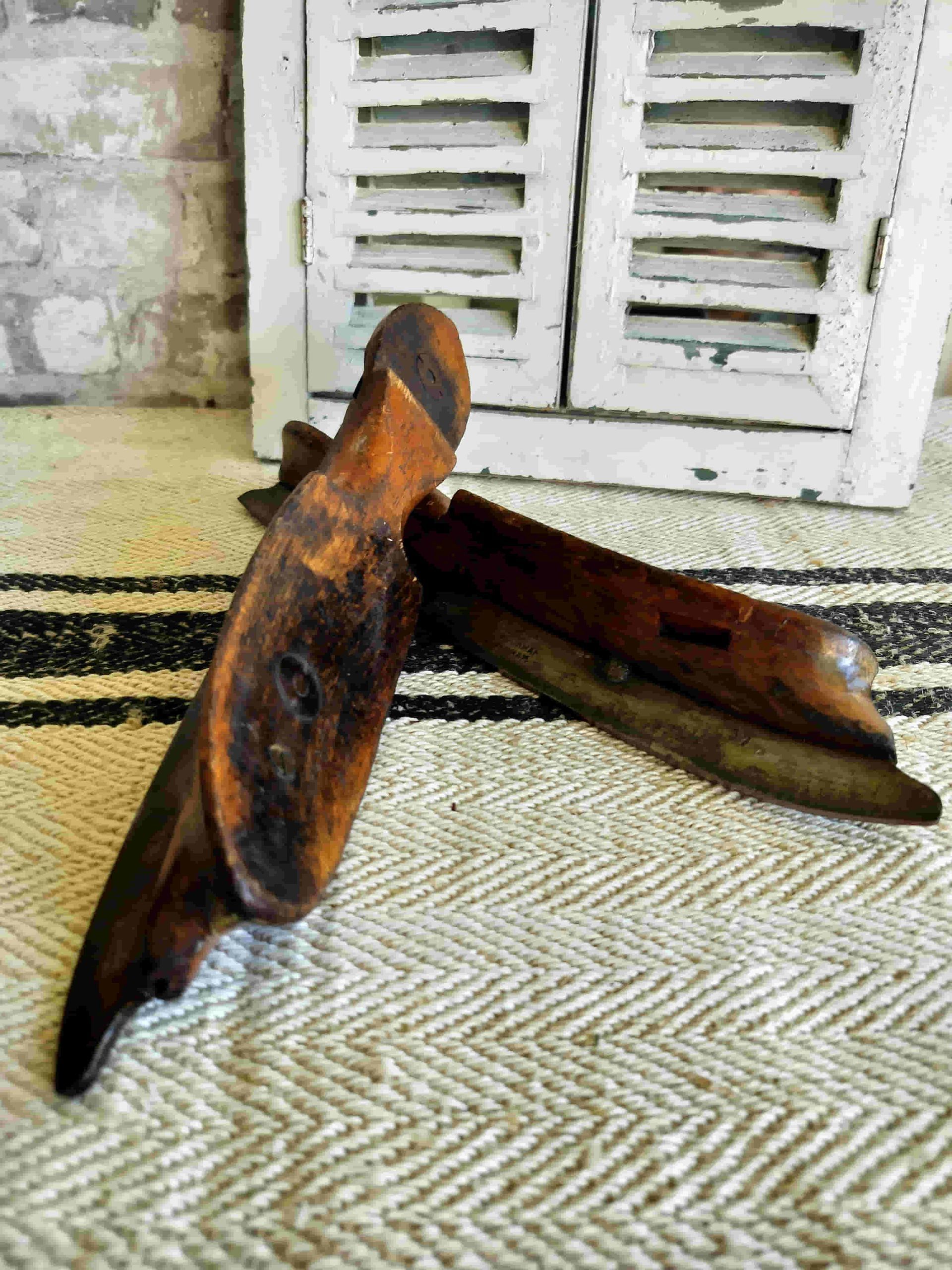 A pair of wooden shoes are sitting on a rug.