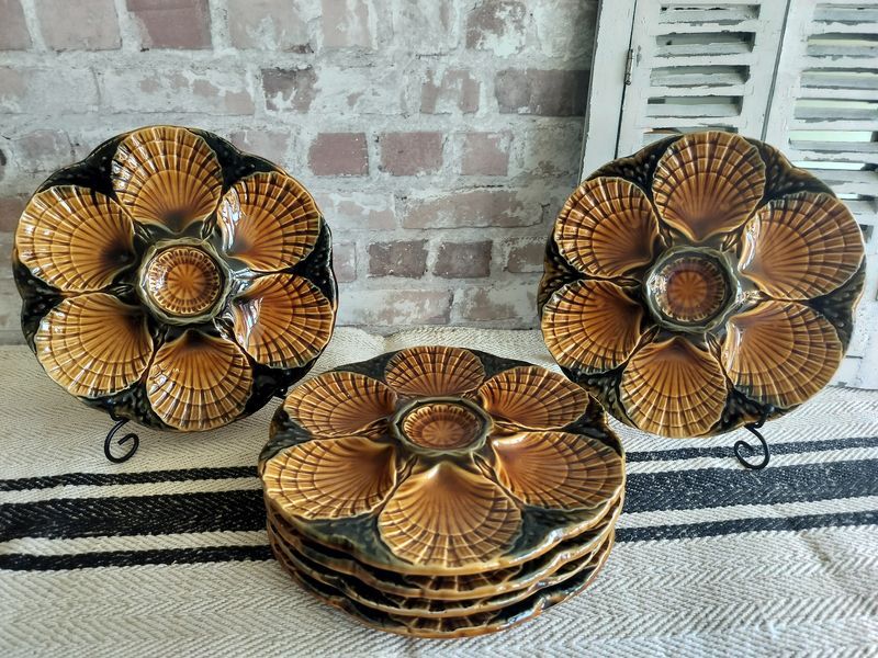 Three plates with shells on them are stacked on top of each other on a table.