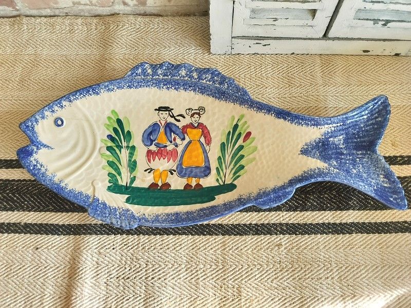 A fish shaped plate with a man and woman on it