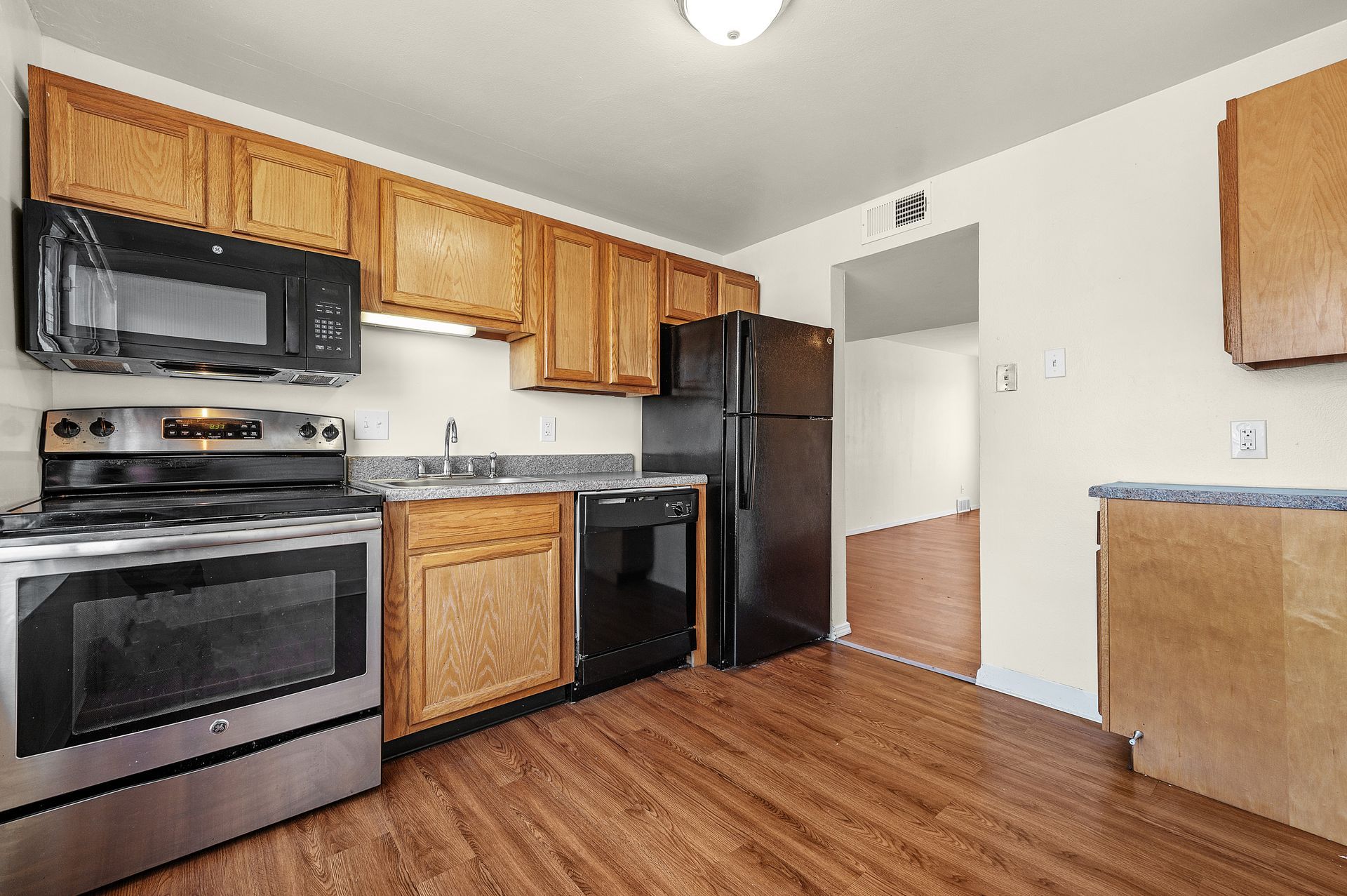 A kitchen with stainless steel appliances and wooden cabinets.