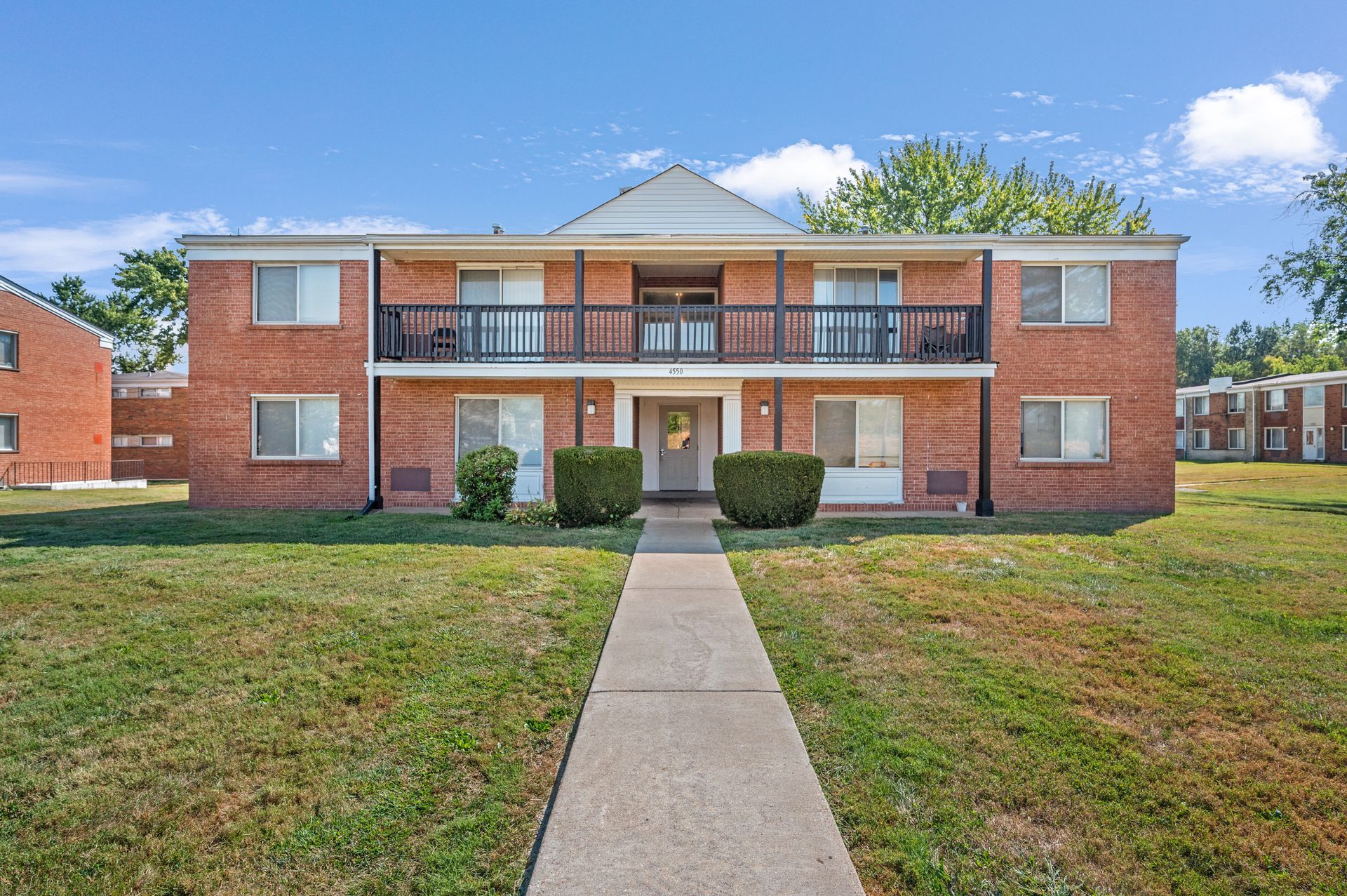 A brick apartment building with a walkway leading to it