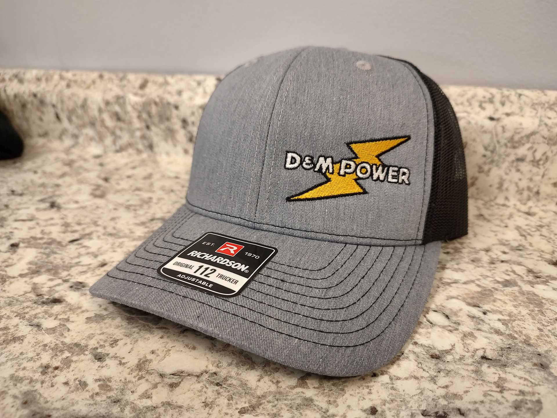 A gray and black baseball cap with a lightning bolt on it is sitting on a counter.