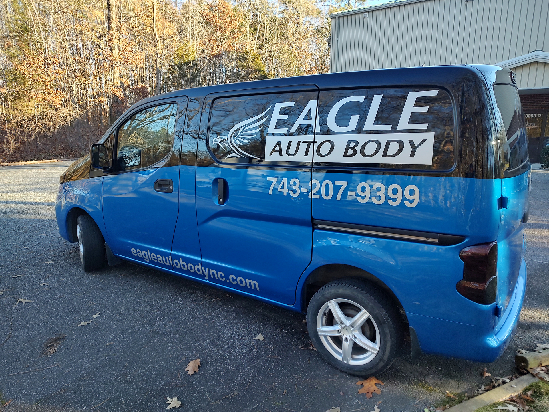 A white truck with the word east coast on the side is parked in front of a building.