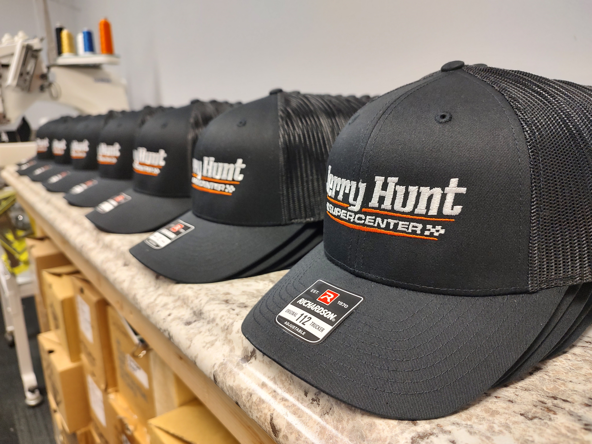 A row of black hats sitting on top of a counter.
