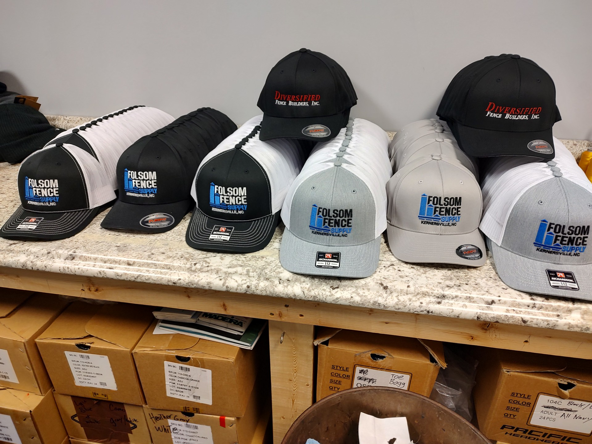 A bunch of baseball caps are sitting on a table.