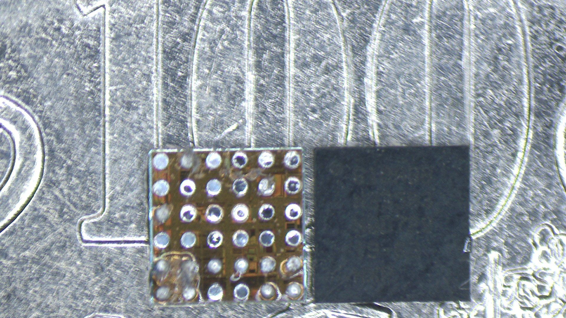 A close up of a coin with a tristart IC and BGA pads on it.